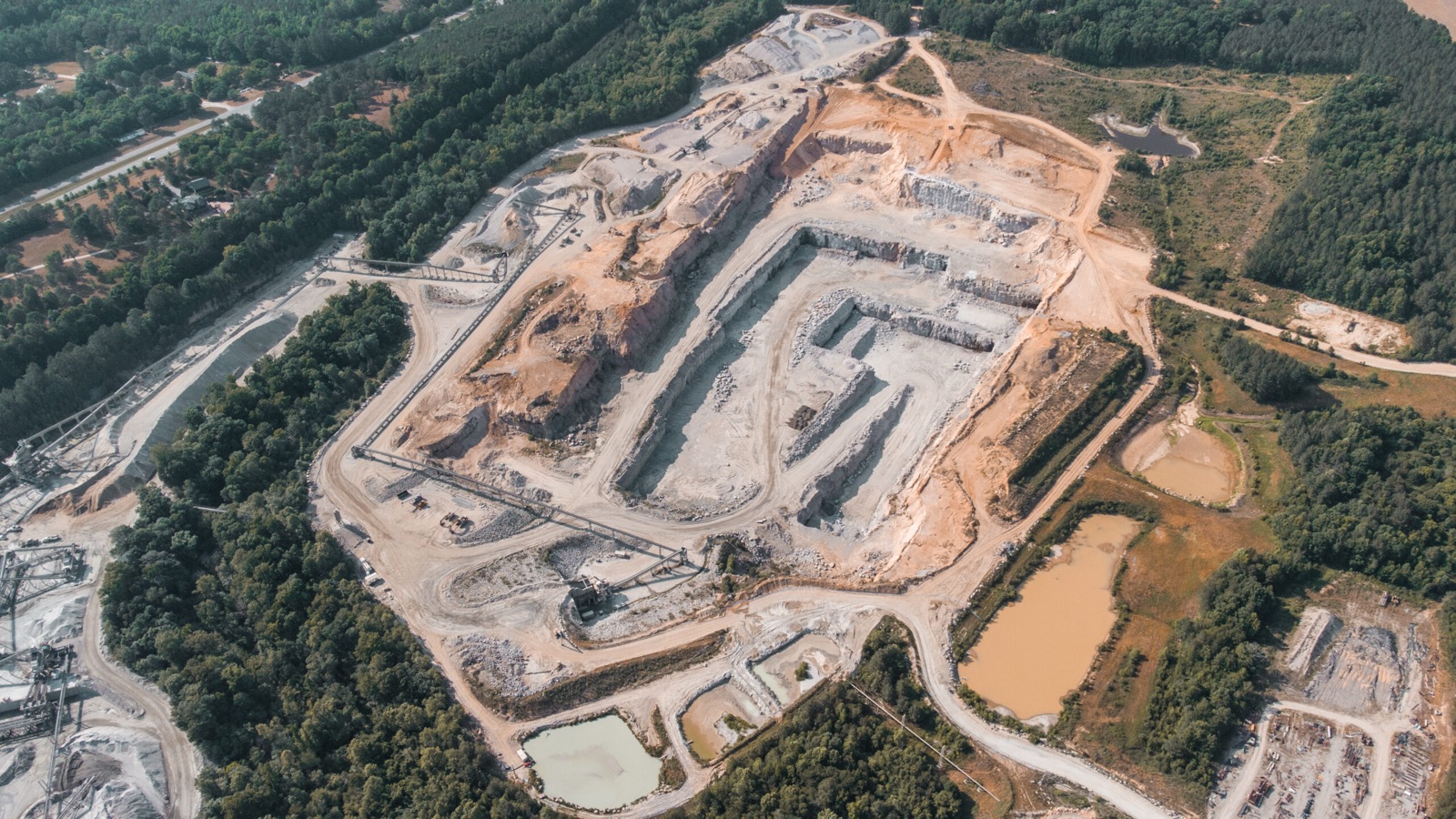 Aerial view of a Sunrock quarry with haul trucks and loaders working the pit