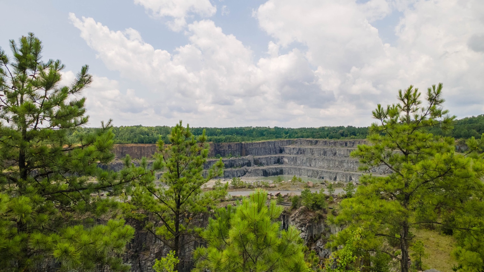 A Sunrock quarry seen through the pines at its rim